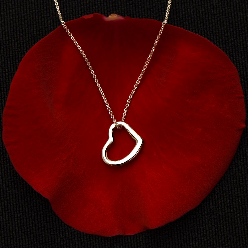 delicate heart necklace displayed on red velvet cloth