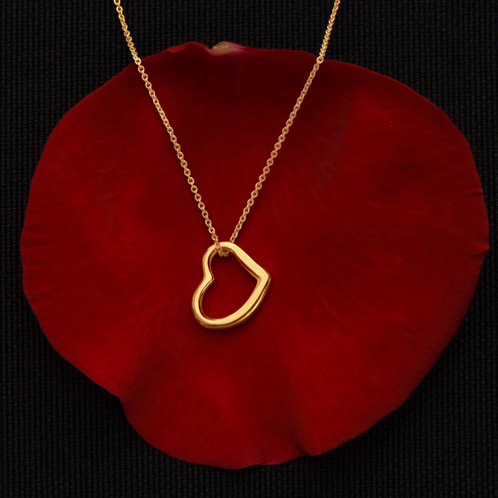 gold delicate heart necklace displayed on red velvet